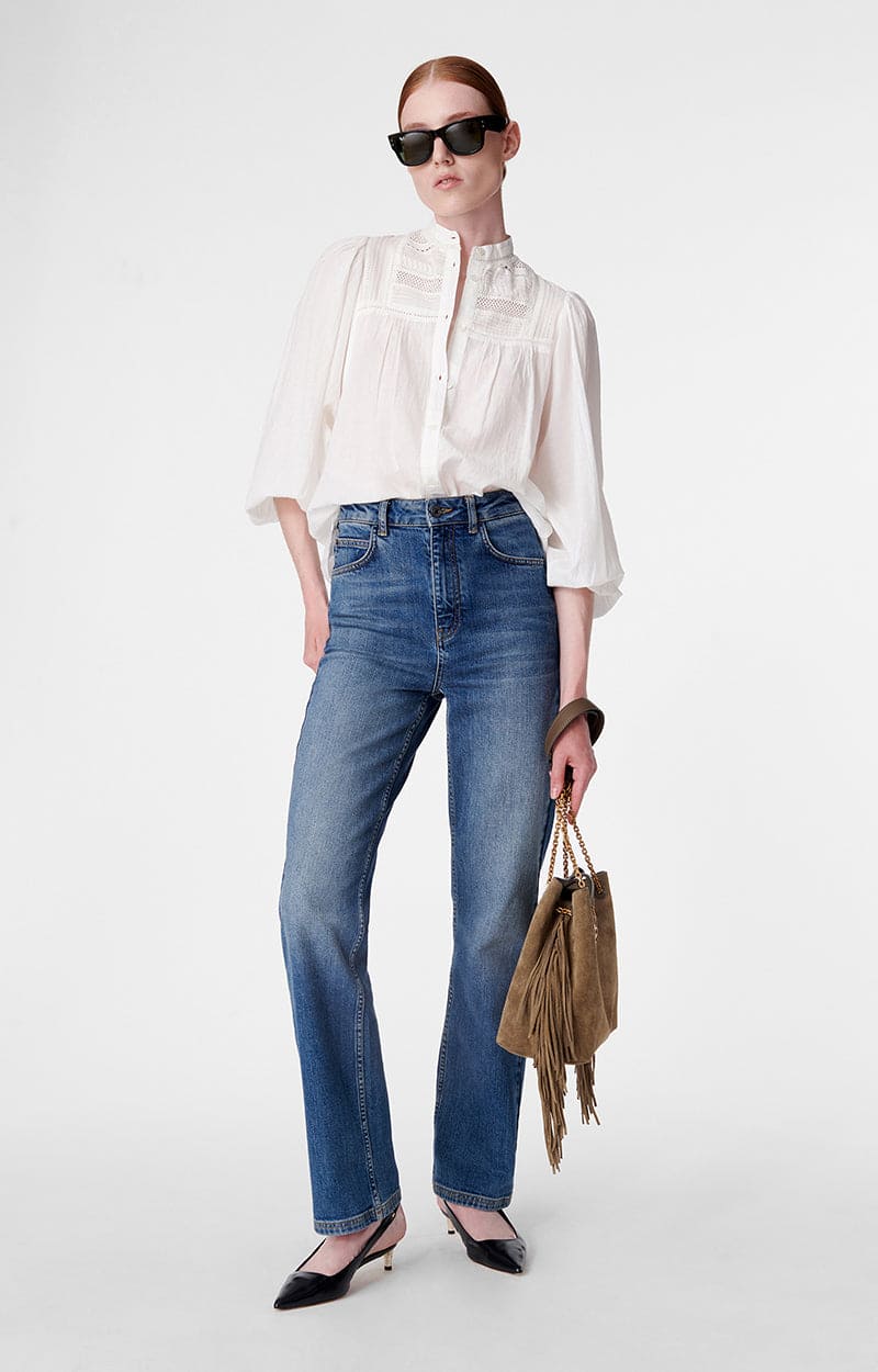 A woman exudes timeless style and sophistication in her Erica Wilson jeans
